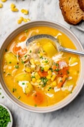 Chicken corn chowder in bowl with spoon.