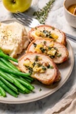 Three slices of prosciutto-wrapped stuffed turkey tenderloin with kale and apple.